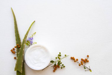 Doğal bitkisel yatıştırıcı krem aromalı yüz maskesi cilt bakımı için aloe vera sağlık hizmetleri arka plan beyaz ahşap üzerinde düz yatıyordu