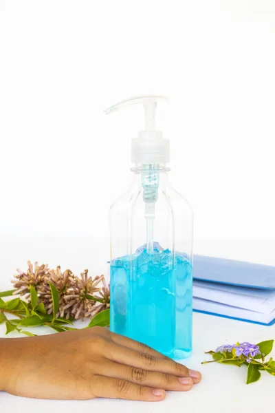 Alkol jeli el dezenfektanlı bir kız eli. Arka planda beyaz ahşap el süslemesi için nemlendiricilerle kendini yumuşak ve yenilenmiş hissediyor.