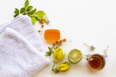 Doğal bitkisel yüz maskesi tatlım, bitkisel sabunla cilt bakımı için limon, temizlik için yüz havlusu, çiçek ylang ylang düzenleme düz arka plan beyaz üzerine yatar 