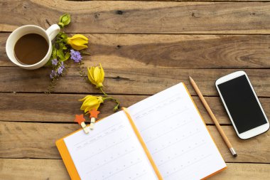 defter günlüğü, cep telefonu ve iş için sıcak kahve sarı çiçek ylang ylang düzenleme düz arka plan ahşap üzerinde yatıyordu 