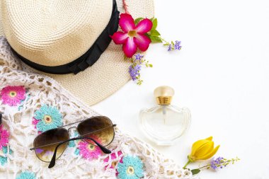 Şişe parfümü, güneş gözlüğü, şapka ve örgü yün kadın aksesuarları.