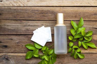 İlk terapi olan pamuk doğal kozmetik içeren serum tonerleri cilt için bitkisel sağlık hizmetleri sunar. Kadın yüzü güzelliği ve yaprak düzenleme düzleştirici arka plan tahtasının üzerinde düz bir şekilde yatar.