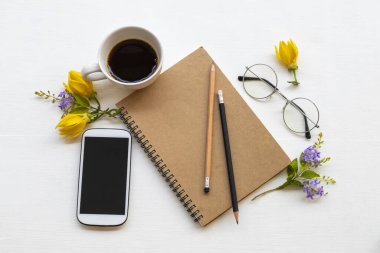 defter günlüğü, cep telefonu ve iş hayatı için sıcak kahve espresso çiçek ylang düzenleme düz arka plan beyaz üzerine yatıyordu