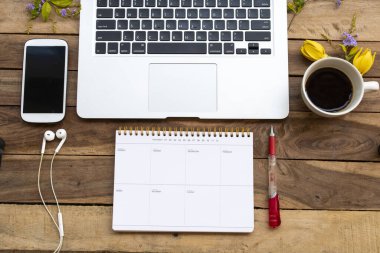 İş için defter planlayıcısı, bilgisayar, cep telefonu. Yaşam tarzı düzenlemesinin sıcak kahve espresso 'su. Arka plan tahtasının üzerinde düz stil yatıyordu.