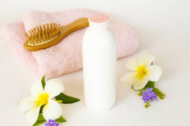 yüz pudrası, fırça tarak ve kumaş beyaz çiçekli kadın sağlık hizmetleri frangipani düzenleme düz arka planda beyaz yatıyordu 
