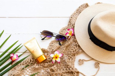 Güneş kremi spf50 cilt sağlığı hizmetleri tığ işi, çiçekler frangipani, güneş gözlüğü, şapka ve hindistan cevizi yaprağı yaz aranjmanında bembeyaz üzerine yatıyordu.