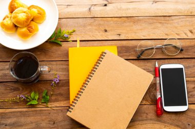defter günlüğü, iş için cep telefonu ekmek, yaşam tarzı düzenlemesi için sıcak kahve espresso arka plan tahtasının üzerinde yatıyordu.