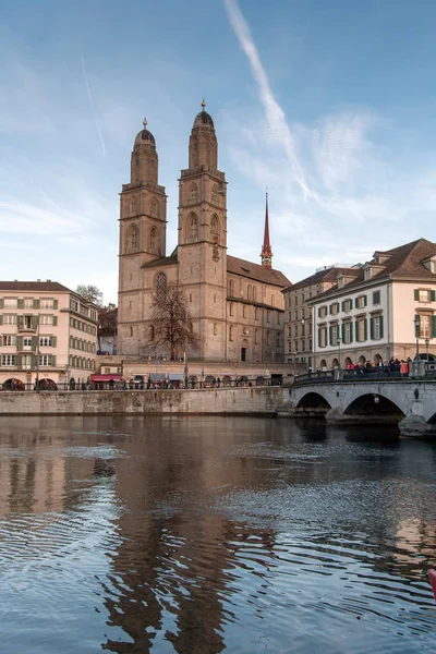 ZURICH, SUIZA - 28 DE OCTUBRE DE 2015: Iglesia de Grossmunster y reflexión en el río Limmat, Zurich — Foto de Stock