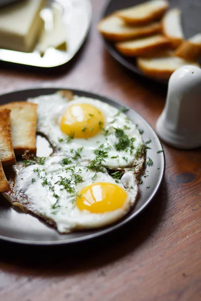 Läckra stekta ägg till frukost på ett träbord — Stockfoto