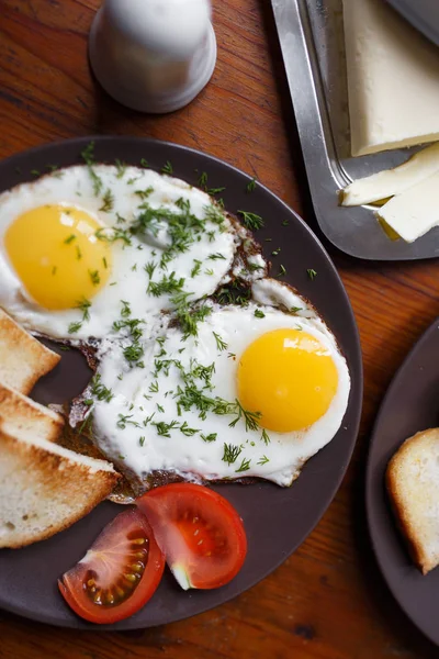 Läckra stekta ägg till frukost på ett träbord — Stockfoto