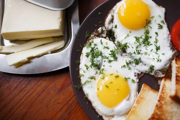 Läckra stekta ägg till frukost på ett träbord — Stockfoto