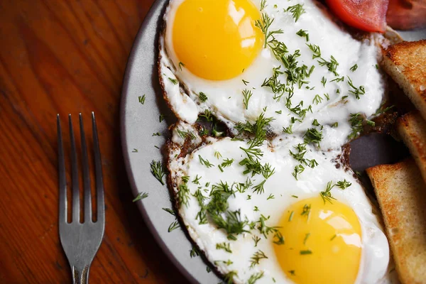 Läckra stekta ägg till frukost på ett träbord — Stockfoto