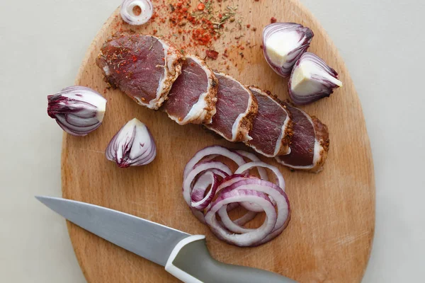Gezouten vlees met kruiden op een houten bord Stockfoto