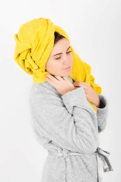 Sevimli kadın kafasına sarı havlu ile gri bornoz