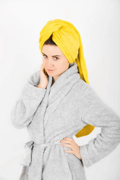 Sevimli kadın kafasına sarı havlu ile gri bornoz