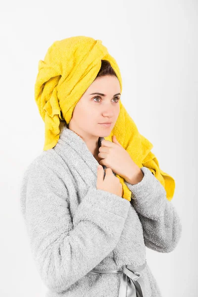 Sevimli kadın kafasına sarı havlu ile gri bornoz
