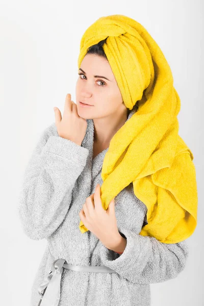 Sevimli kadın kafasına sarı havlu ile gri bornoz
