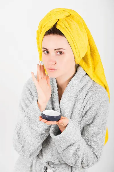 Sevimli kadın kafasına sarı havlu ile gri bornoz