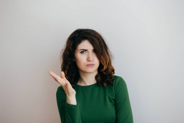 Kıvırcık saçları hafif bir arka plan üzerinde bir şey tarafından kızdırdı olan kadın 