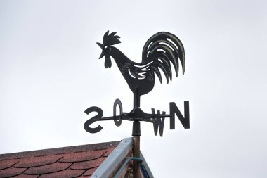 rooster weathervane on house  clipart