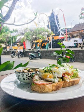 Ekmek üzerinde mantar ile Kahvaltıda yumurta haşlanmış. Bulanık bir arka plan Bali Adası binanın arkasında.