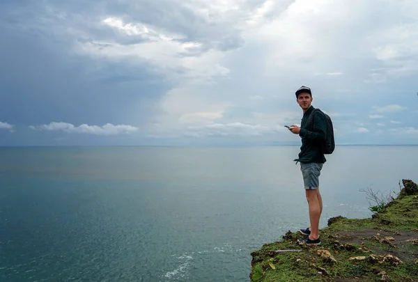 Jeune Homme Avec Sac Dos Debout Sur Une Falaise Pointant — Photo