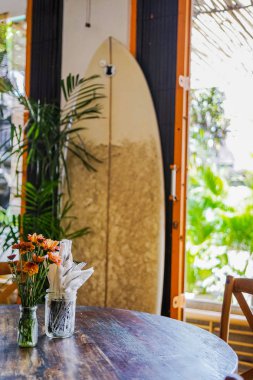 Ahşap masa kafede. Arka planda bir sörf tahtası olduğunu.