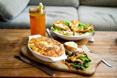 Raclette Tartiflette ve salata Chevre Chaud - Fransız mutfak. Bir ahşap tahta üzerinde et güveç. Yan görünüm