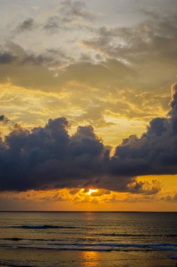 Turuncu günbatımı Uluwatu Bali Adası. Büyük bulutlar okyanus üzerinde asılı. Kopya alanı ile yan görünüm