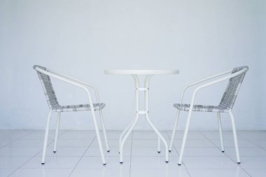 Kafede şeffaf beyaz tablo. İki Rattan Koltuk içinde belgili tanımlık geçmiş. Bütün odayı beyazdır. Kopya alanı ile yan görünüm