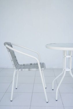 Kafede şeffaf beyaz tablo. Rattan Koltuk içinde belgili tanımlık geçmiş. Bütün odayı beyazdır. Kopya alanı ile yan görünüm