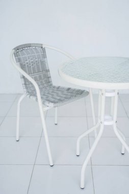 Kafede şeffaf beyaz tablo. Rattan Koltuk içinde belgili tanımlık geçmiş. Bütün odayı beyazdır. Kopya alanı ile yan görünüm