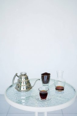 Kahve kahve çekirdekleri ve iyi bir kahve kokusu için bir sürahi ile şeffaf cam ve metal su ısıtıcısı Servisi. Arka plan bulanık, bembeyaz. Kopya alanı ile yan görünüm