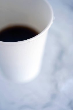 Kağıt (tek kullanımlık) beyaz bardak kahve yakın çekim ile. Arka plan bulanık. Kopya alanı ile üst ve yan görünüm