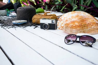 Minimal styled flat lay isolated on white wood background. Feminine desk top view with summer accessories: hat, sunglasses, vintage photo camera, handbag, shell, anchor, boat, stones, fish clipart