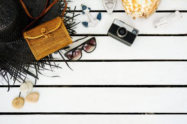Beyaz ahşap arka plan üzerinde izole Minimal tarz düz yatıyordu. Yaz aksesuarları ile kadınsı Resepsiyon üstten görünüm: şapka, güneş gözlüğü, vintage fotoğraf makinesi, el çantası, kabuk, çapa, tekne, taşlar, Balık