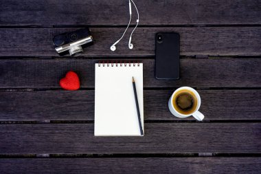Koyu ahşap arka plan üzerinde izole Minimal tarz düz yatıyordu. Dostum yaz aksesuarları ile Resepsiyon üstten görünüm: kalp, smartphone, vintage fotoğraf makinesi, kulaklık, kahve, defter. Kadının gün kartpostal