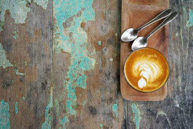 Şeffaf fincan cappuccino kahve masada bir eski vintage ahşap ahşap bir stand ve bir çay kaşığı. Kopya alanı ile Üstten Görünüm