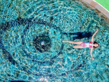 Güzel bir rakam ile genç seksi kız yüzen ve otel büyük Havuzu, güneşlenme, yatıyor tadını çıkarın. Mükemmel bir vücut ve sağlıklı cilt, Kızıl saçlı ve mayo bikini. Bali Ubud. Yukarıdan havadan görünümü