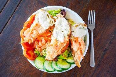 Hassas bir krem ile yumuşak ekmek dilimleri de füme somon salatası. Restoran ve ahşap bir masa. Bir kız pembe bir masada oturur ve bir salata yiyor. Kopya alanı ile Üstten Görünüm