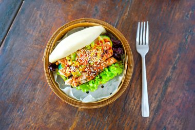 Izgara orkinos ve Guakamole bao. Yemek çubukları ile el. Ahşap masa arka planda bir restoran. Yeşil Çince çay çaydanlık. Geleneksel Çince ve Fransız mutfağı. Kopya alanı ile Üstten Görünüm