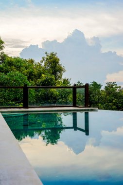 Beach shoreline görünümünü. Ön planda, ağaçlar ve gökyüzü havuzda yansıtılır. Bali Adası, Lovina plaj. Kopya alanı ile yan görünüm