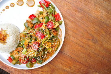 Tavuk kung pao beyaz bir tabak ve ahşap masa lambası. Çin yemeği. Yemek çubukları. Bulanık bir arka plan arka yüzünde bir beyaz tuğla yastık bir kelime sevgi ile kaplıdır. Kopya alanı ile Üstten Görünüm