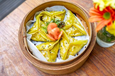 Kuşkonmaz tofu hamur tatlısı - yakın çekim. Gıda sopa ve Çin yemeği. Çiçekler ve el ile ahşap bir masaya. Makro. Kopya alanı ile Üstten Görünüm