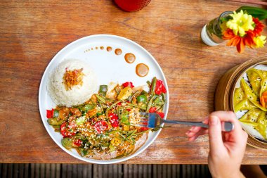 Tavuk kung pao beyaz bir tabak ve ahşap masa lambası. Çin yemeği. Yemek çubukları. Bulanık bir arka plan arka yüzünde bir beyaz tuğla yastık bir kelime sevgi ile kaplıdır. Kopya alanı ile Üstten Görünüm