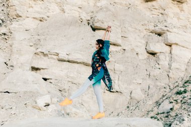 Genç kadın poz ve dans renkli elbise giymiş