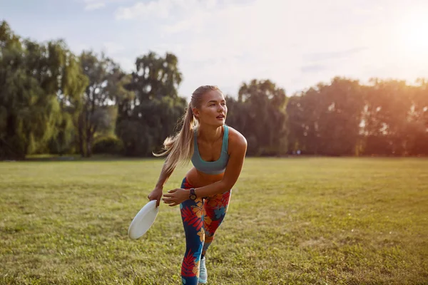 Молодая спортсменка играет с летающим диском, конечная — стоковое фото