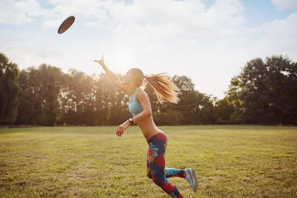 Disk, uçan ile oynayan genç atletik kız nihai — Stok fotoğraf