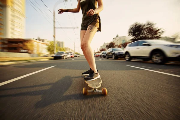 Krásná mladá dívka s tetováním na koni longboard za slunečného počasí — Stock fotografie