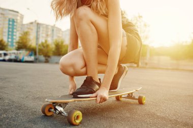 Güneşli havalarda longboard sürme dövmeli güzel genç kız